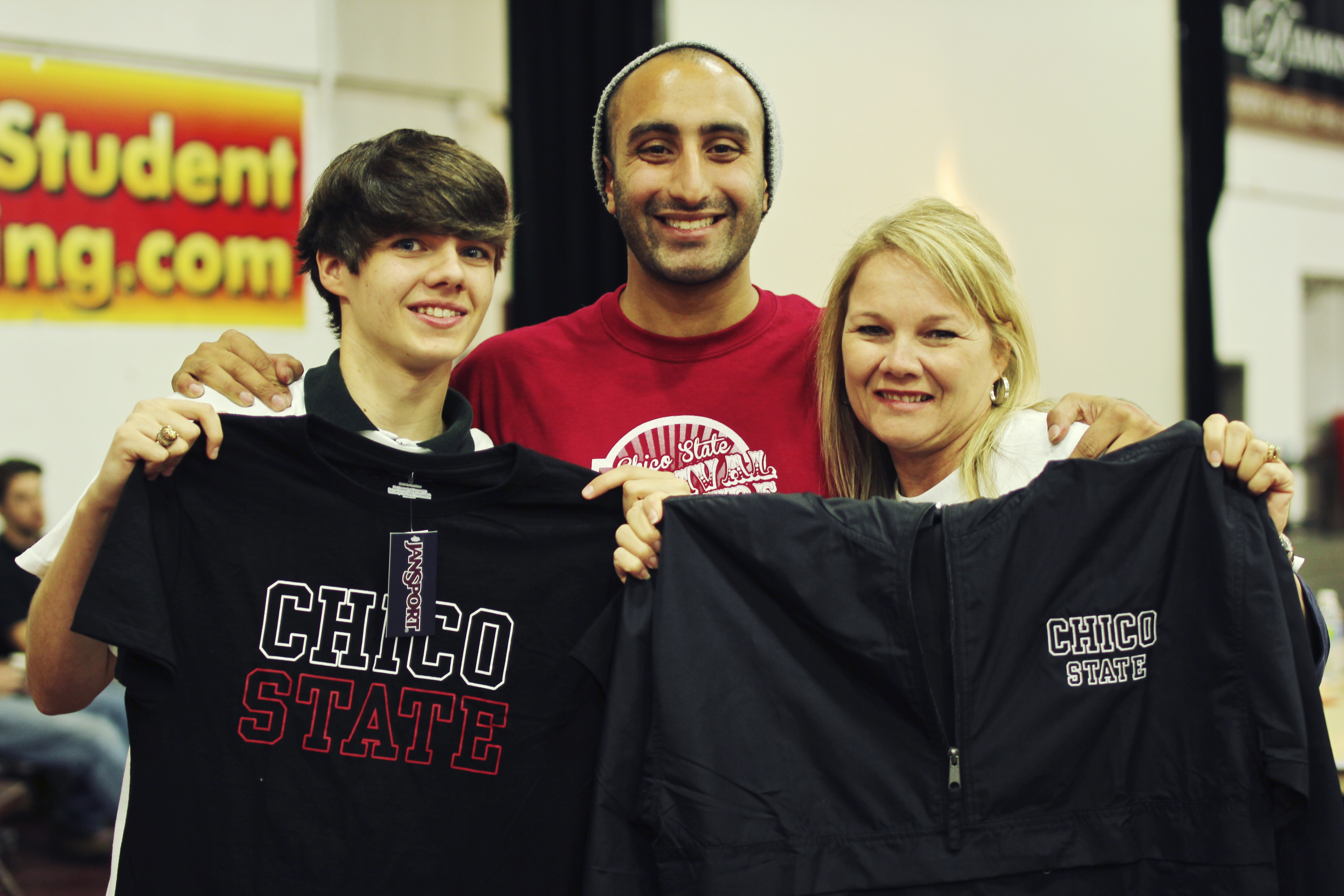 group of 3 people holding Chico state apparel