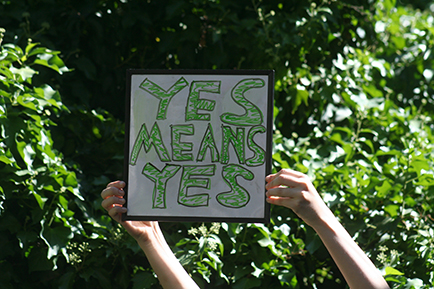 Hands holding up a sign saying Yes means Yes