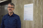 Dean of the Library stands next to a new welcome sign