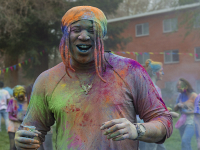 Man covered in colored powder.