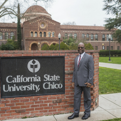Milton Lang standing next to the CSU, Chico sign.
