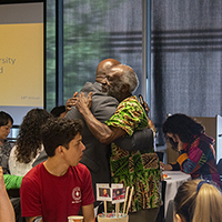 Milton Lang and James Luyirika-Sewagudde Jr. share a hug during the awards dinner.
