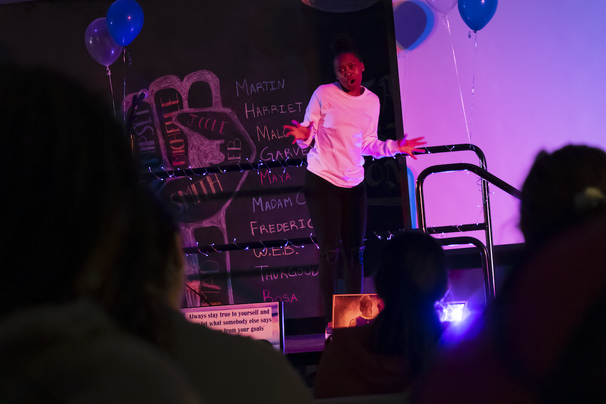Student on stage at Poetry Slam. 
